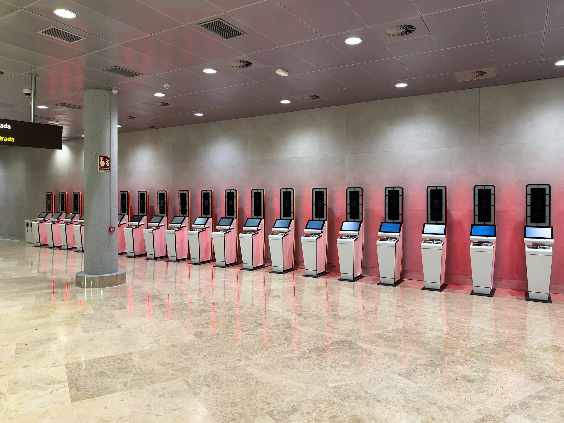 A row of self-service Entry/Exit System kiosks in an airport hall in Valencia, Spain