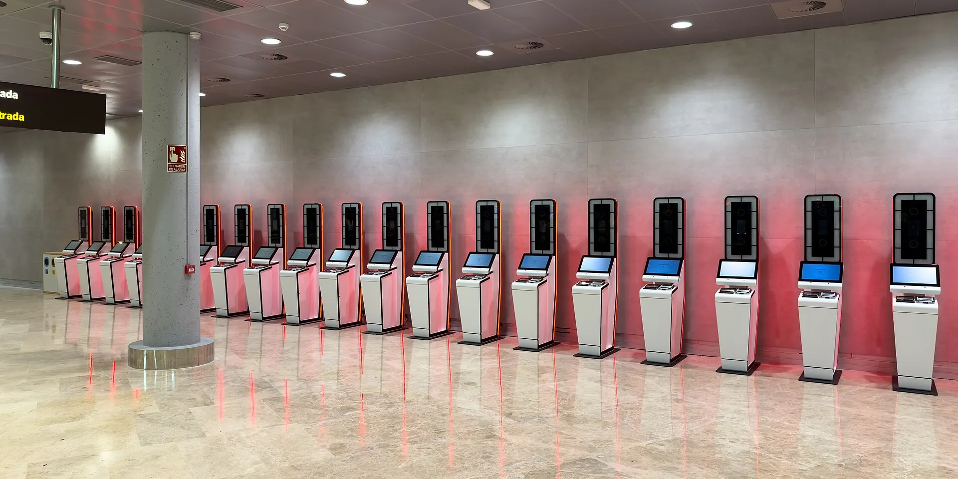 A row of self-service Entry/Exit System kiosks in an airport hall in Valencia, Spain