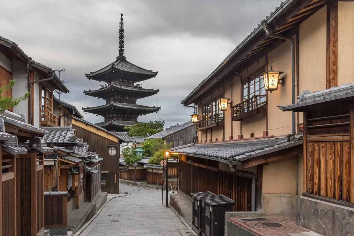 Yasaka-dori in Kyoto early in the morning, with street lanterns and the five-storey Tower of Yasaka at the top of the street