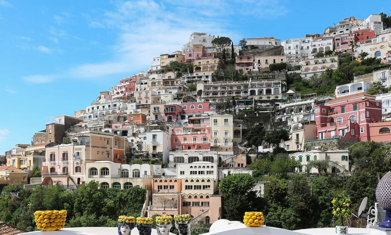 View of Positano’s stacked cliffside houses and beach from the sea on the Amalfi Coast