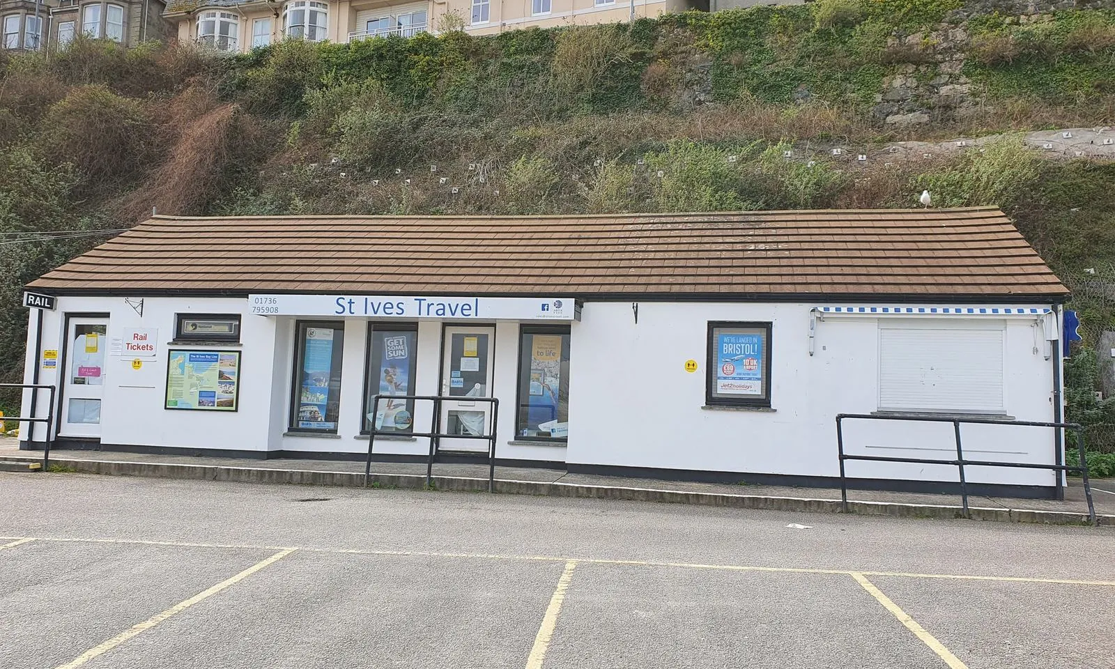 St Ives Travel, a small travel agency in a single-storey building in St Ives, Cornwall, with posters and offers in its windows