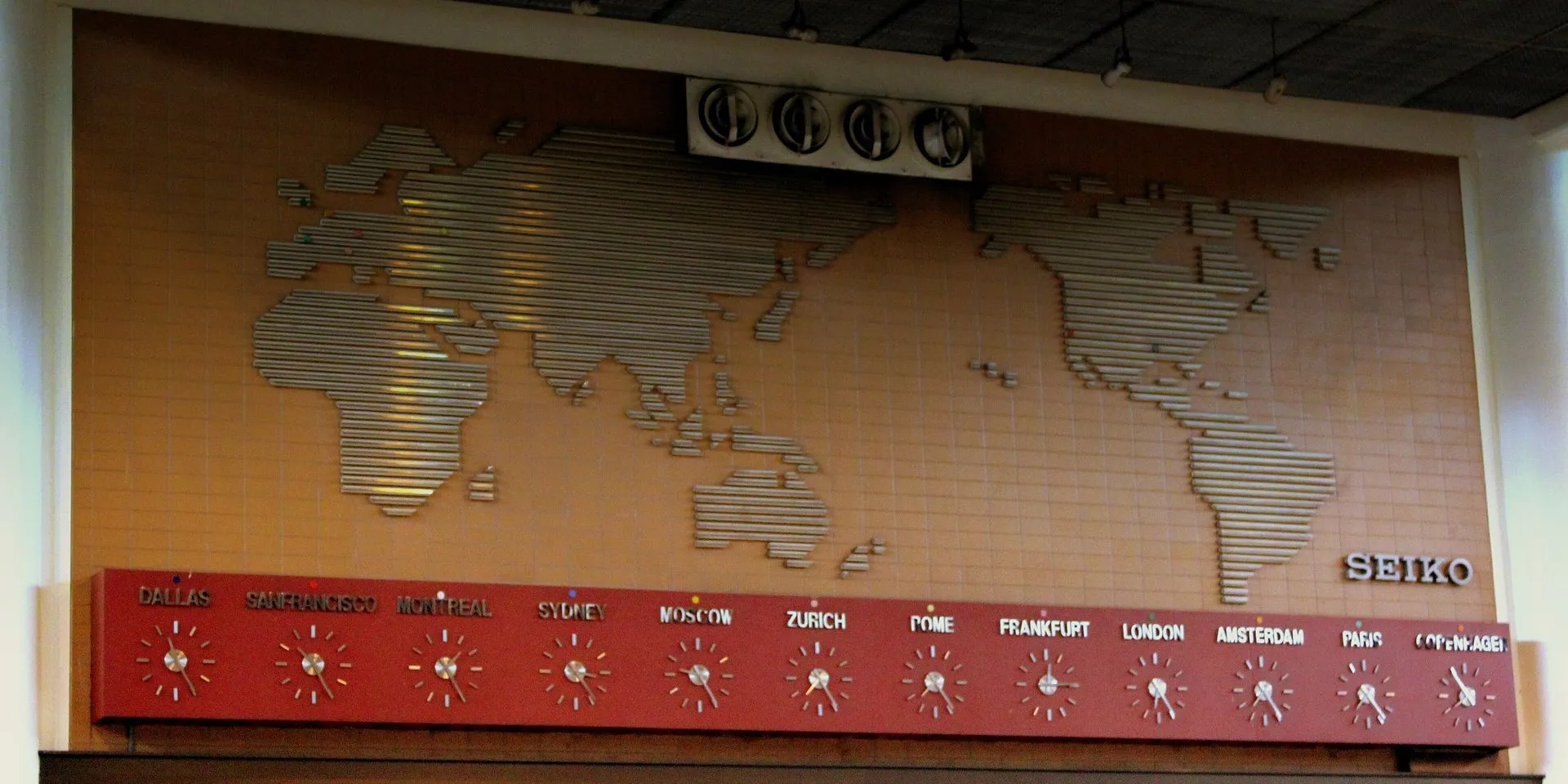 A wall of clocks at Don Mueang Airport in Bangkok showing the time in cities such as Dallas, Sydney, Moscow, London and Paris beneath a world map